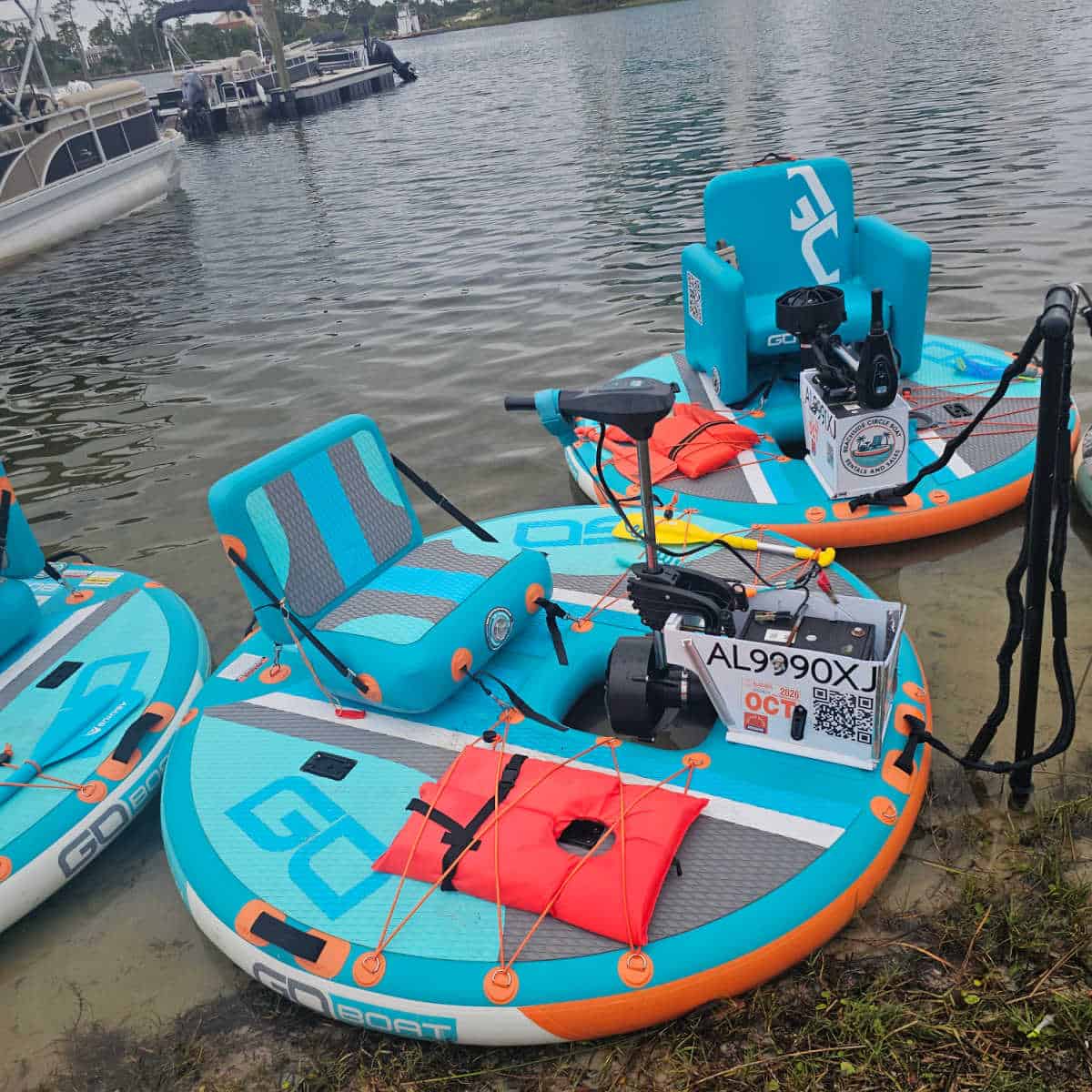 Beachside Circle boats in the water with lifejackets attached to them, pontoon boats in the background