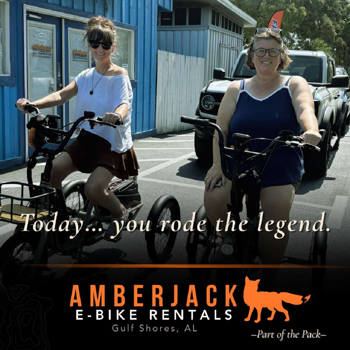 Tammilee and her friend Amy on t-trikes next to a blue building