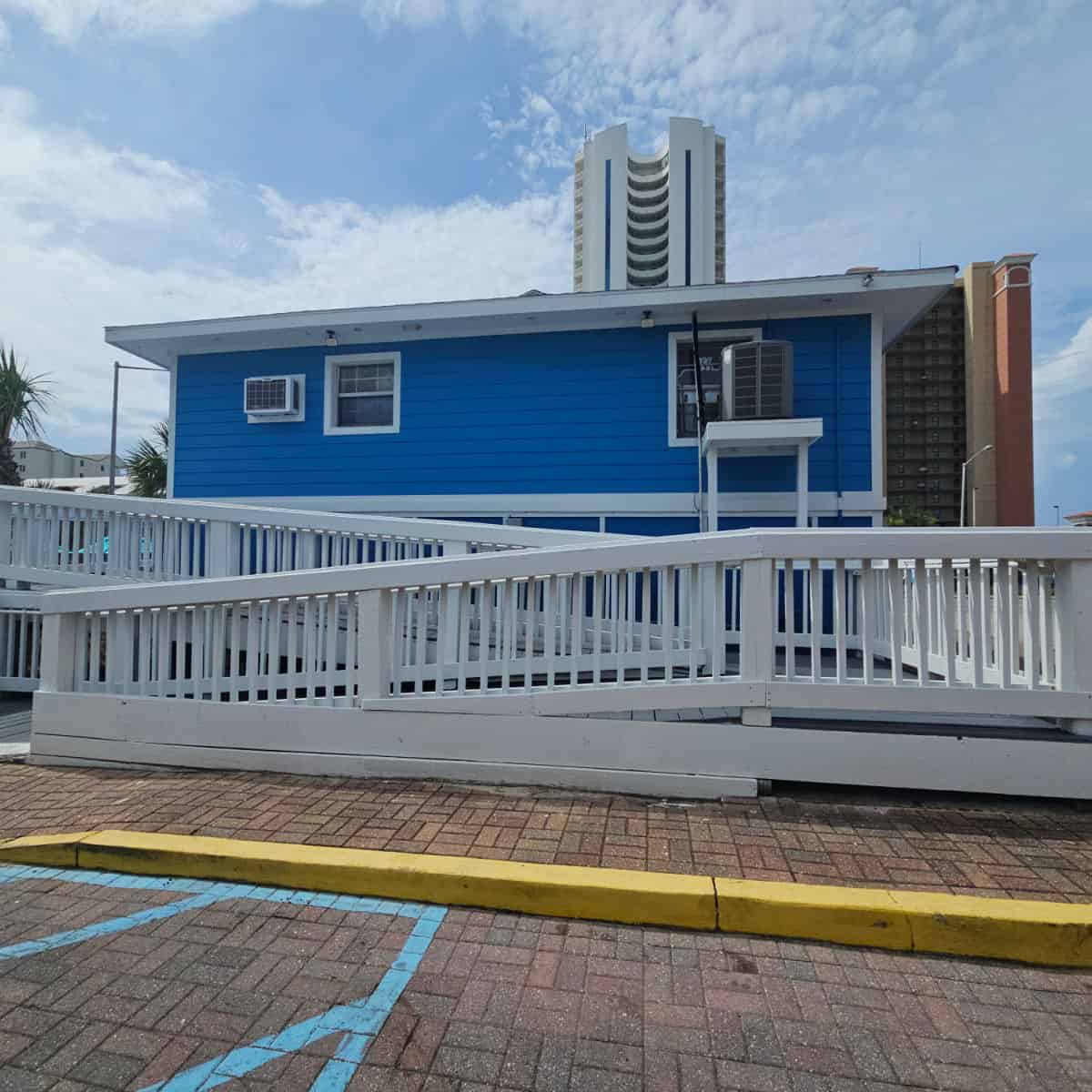 white accessibility ramp going up the back of a blue building