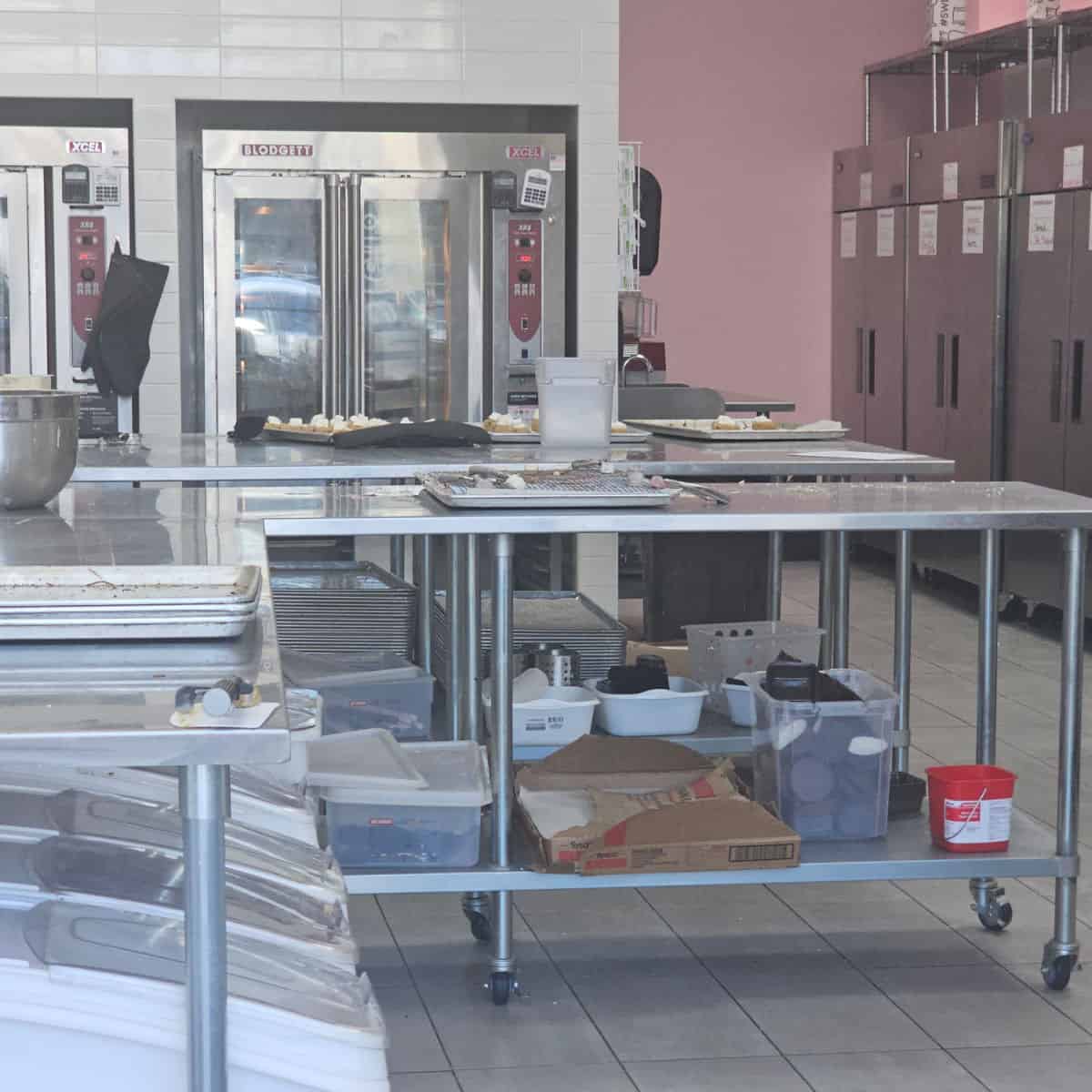crumbl bakery area with trays of cookies and supplies
