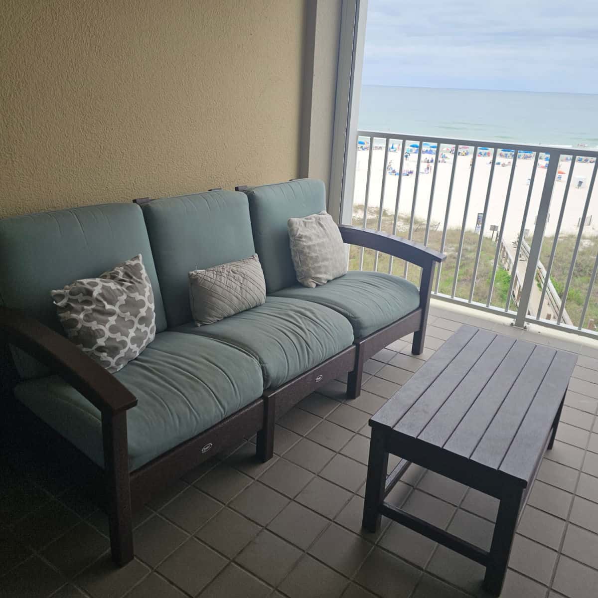 balcony with couch and table, views out to the beach and Gulf waters