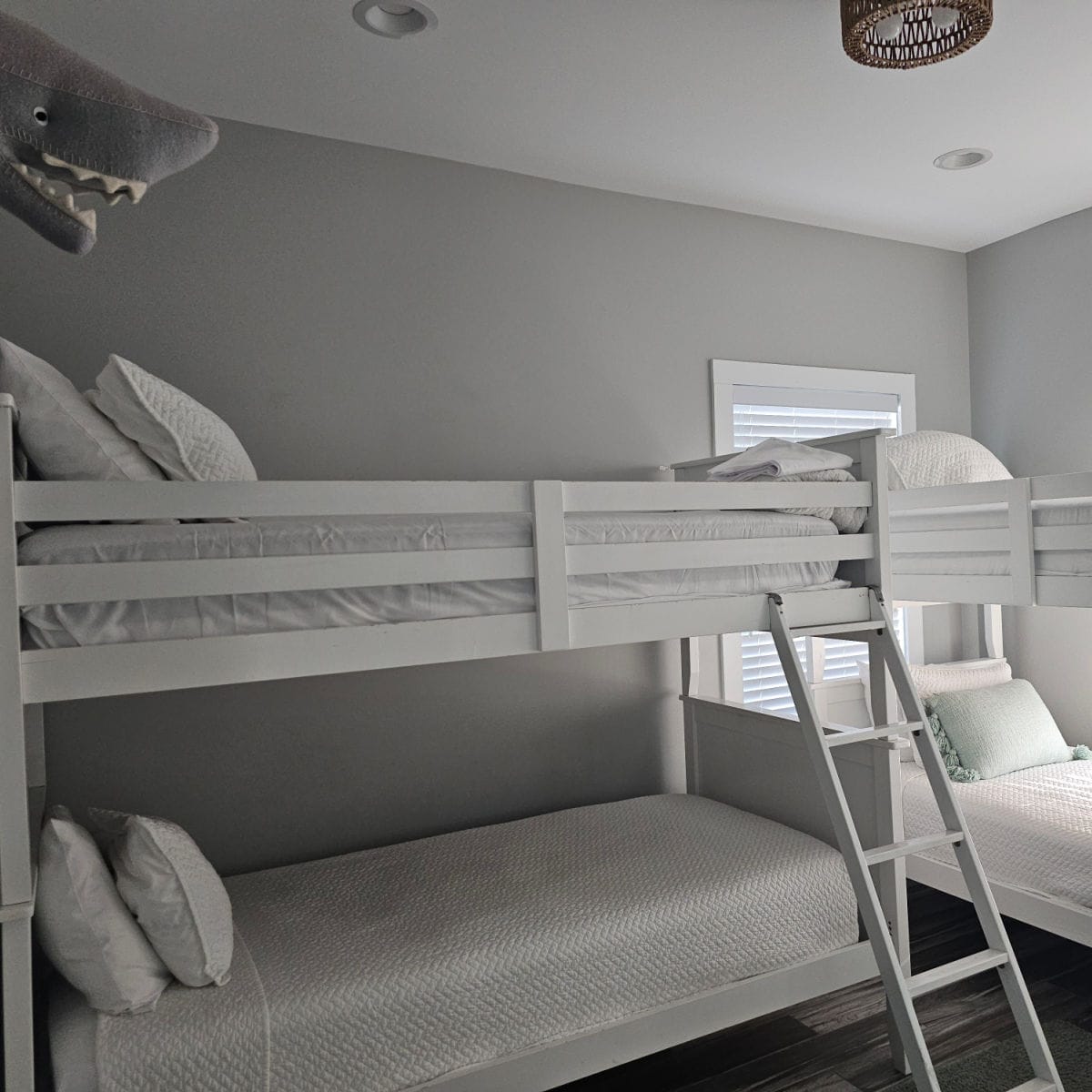 Room with bunkbeds next to each other and a shark head on the wall