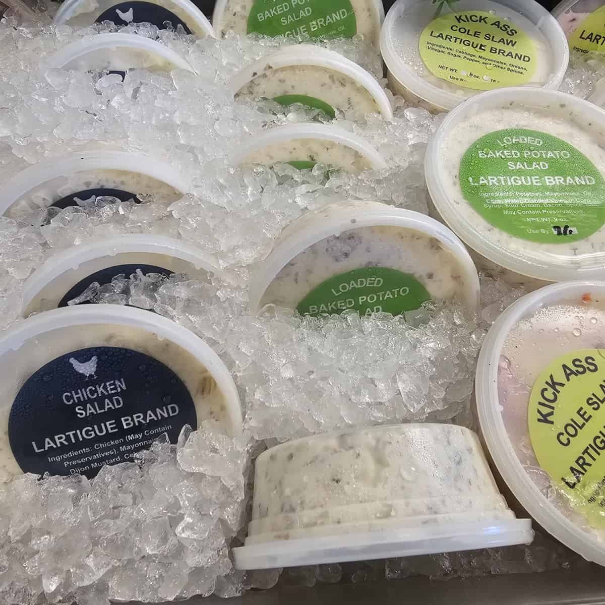 lartigue brand baked potato salad and chicken salad in containers on ice