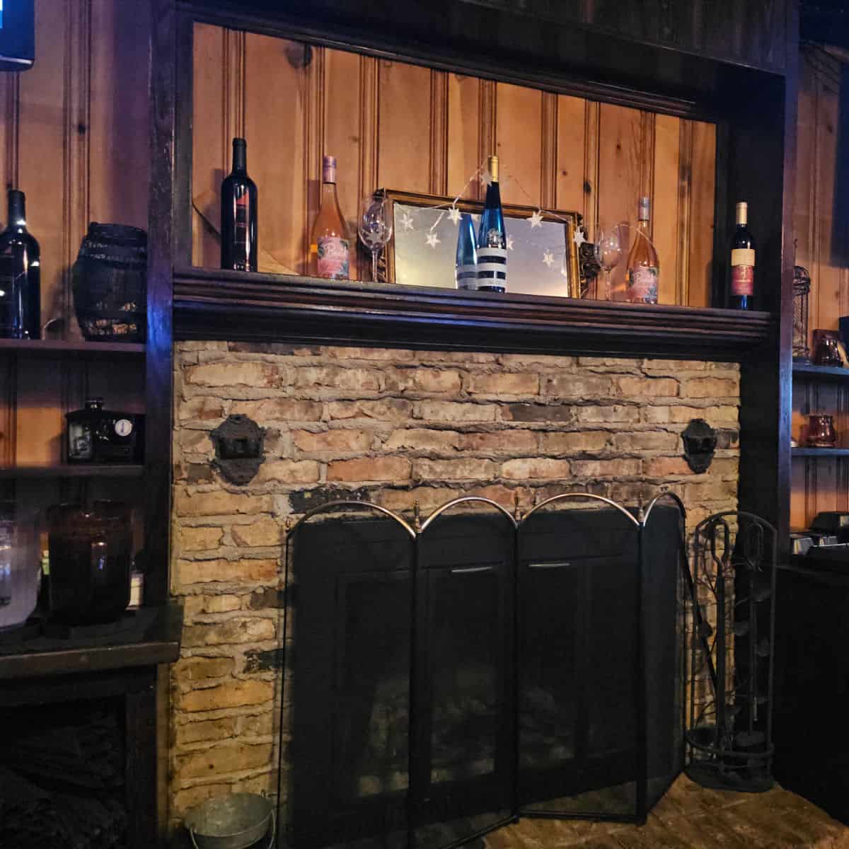 fireplace with bottles on the mantle and star decorations