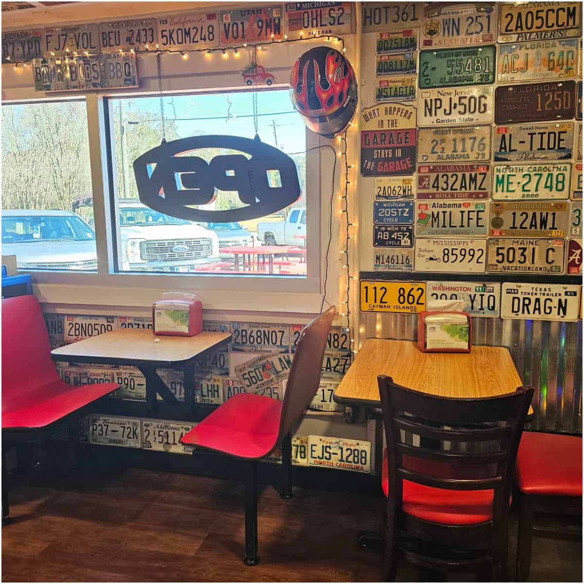 restaurant wall covered in license plates with tables and chairs againt the wall