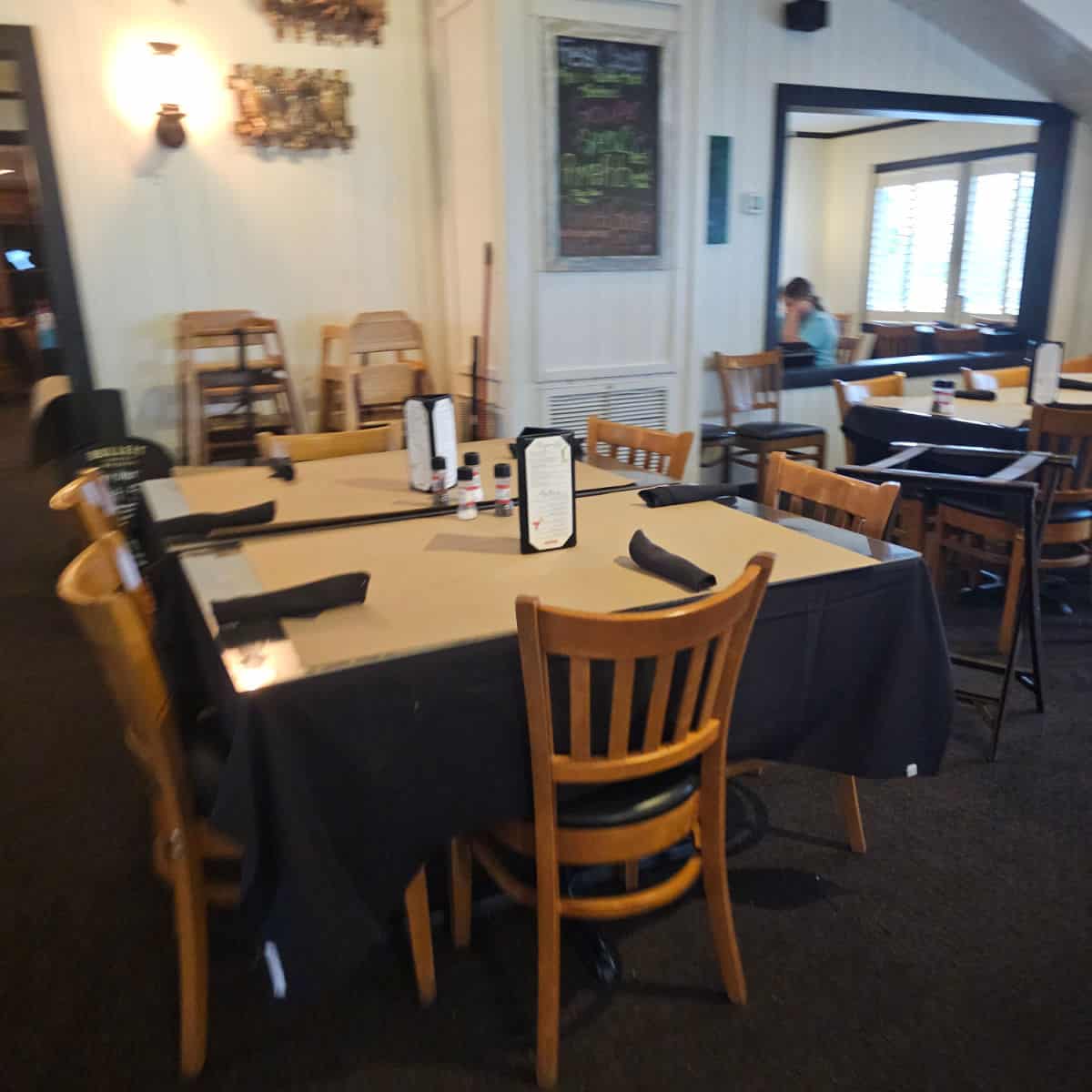 indoor seating with tables and chairs, chalkboard on the wall