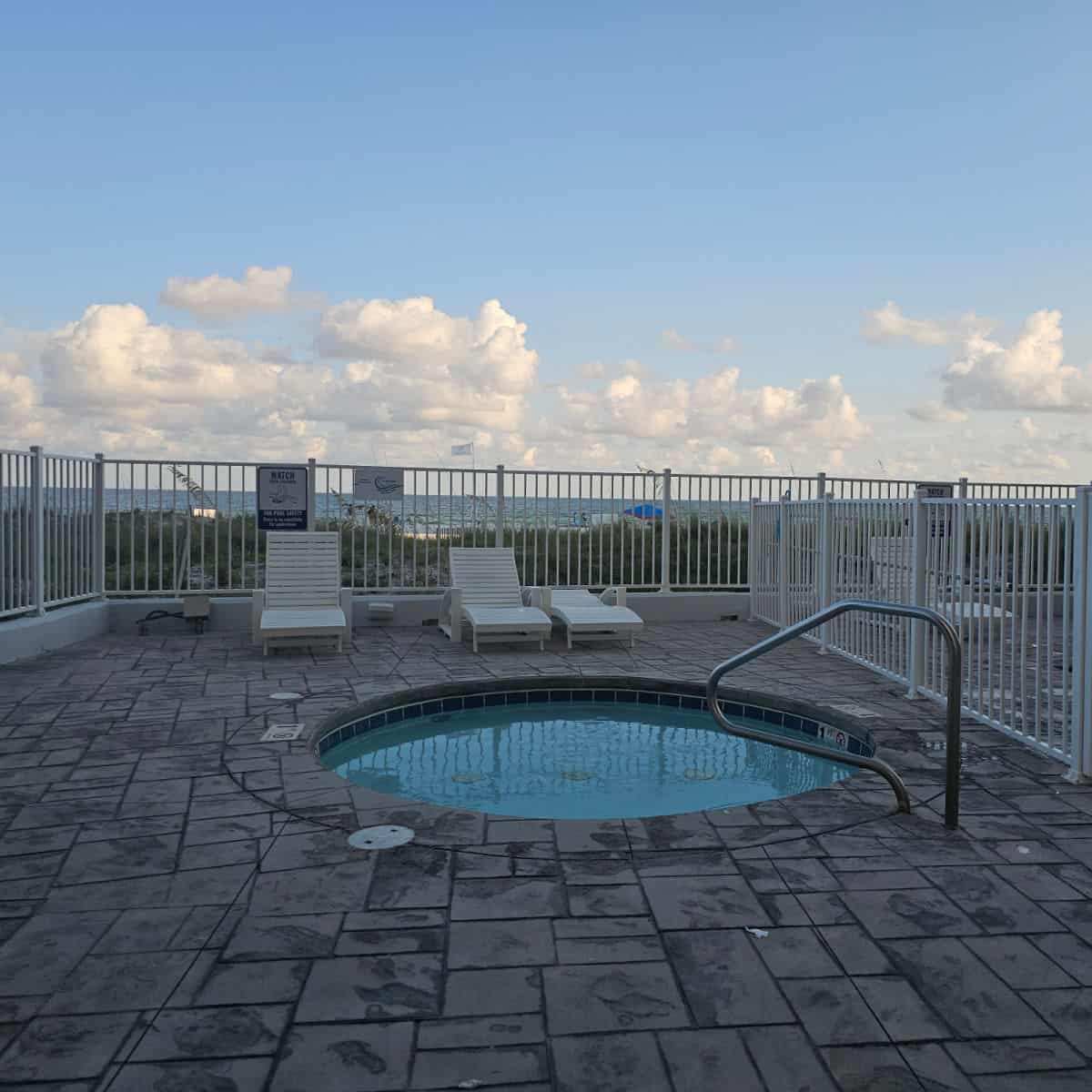 small kiddie pool with a white fence around it, couple of lounge chairs on the deck