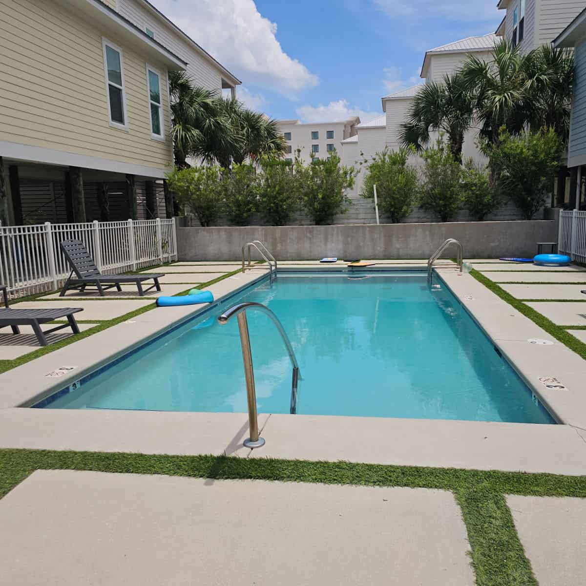 outdoor pool with chairs along the side beach vacation rentals near the pool
