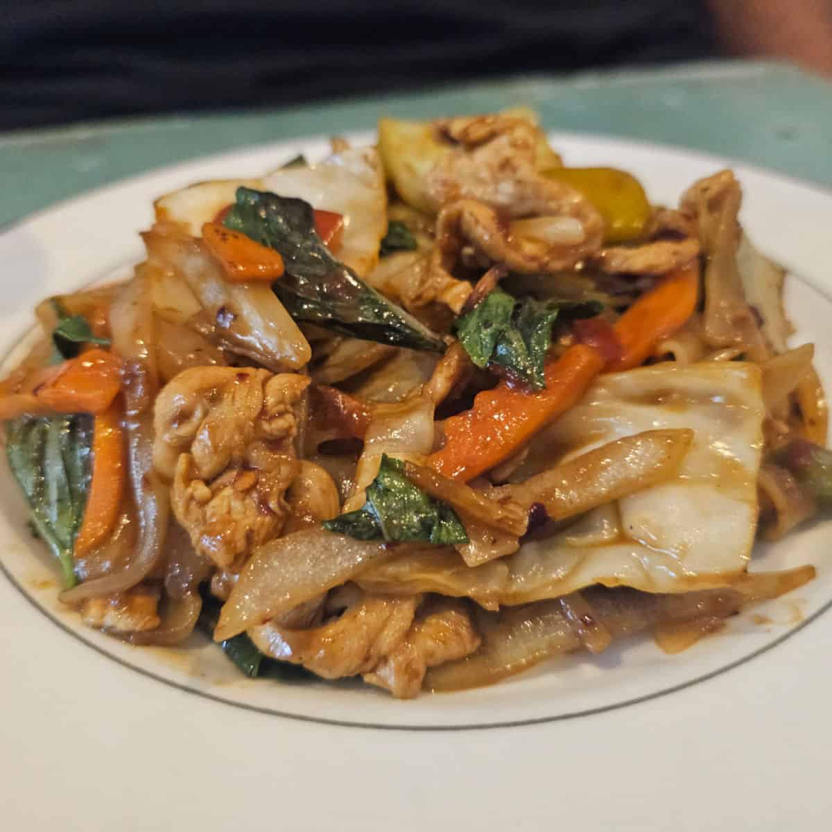 Drunken Noodles on a white plate on a table