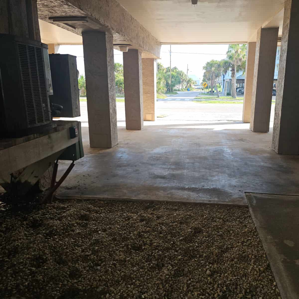 Parking in between columns under a building looking out towards the road