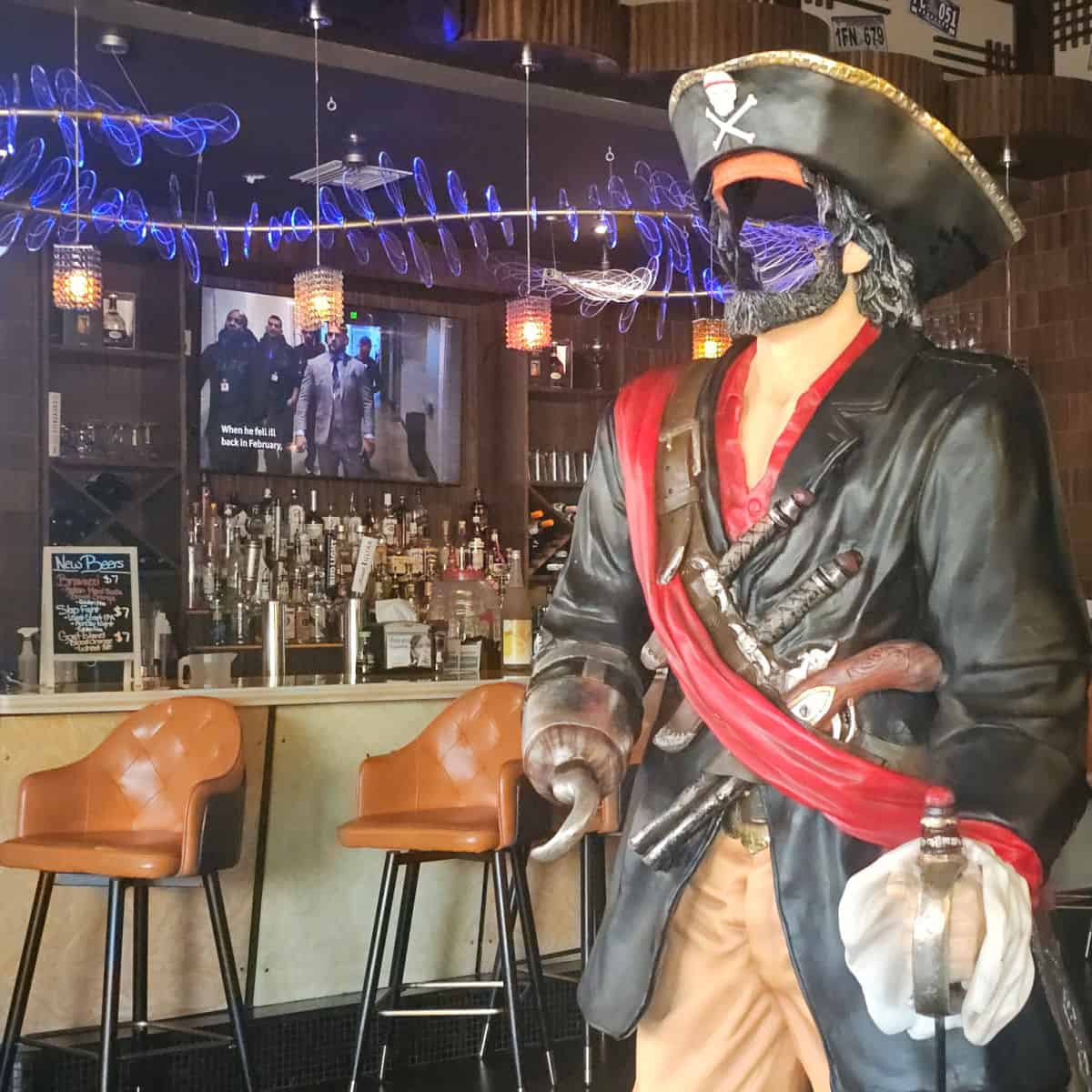 pirate figure near a bar with leather chairs and blue lights above the bar