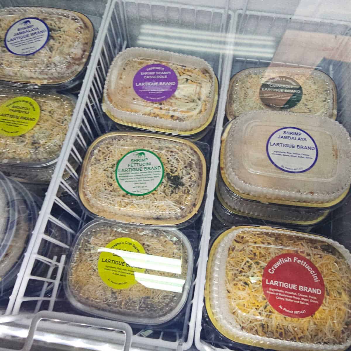 Lartigue brand take and bakes in a a cooler case with shrimp jambalaya, crawfish fettuccini, shrimp fettuccini, shrimp scampi casserole