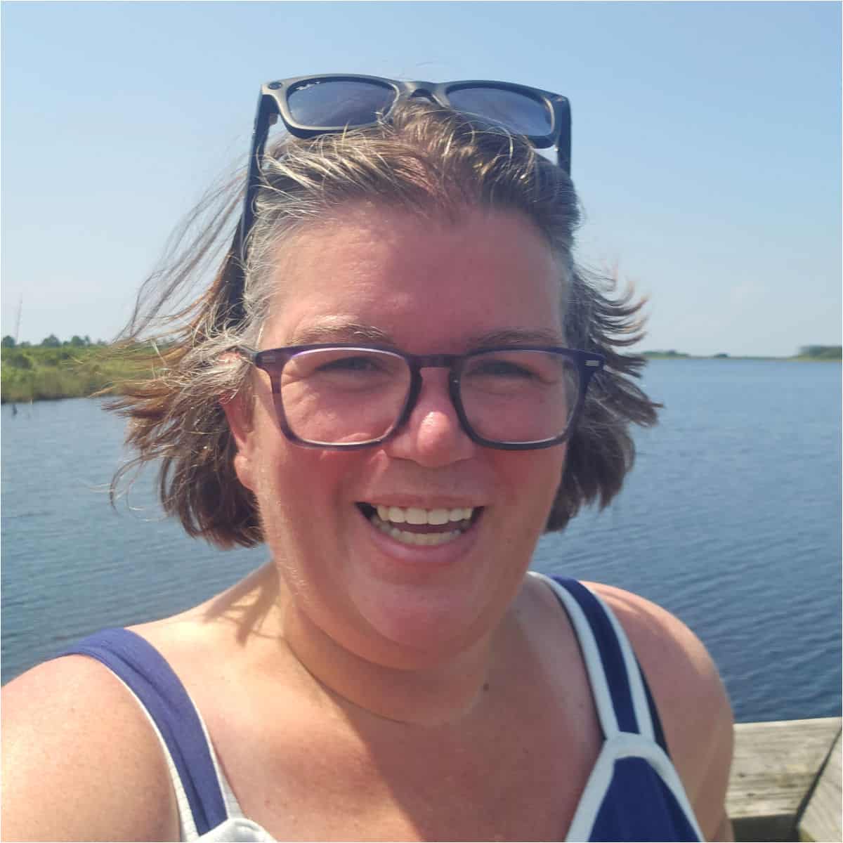 Tammilee smiling with water behind her on a pier