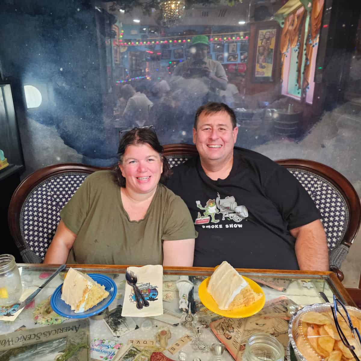 Tammilee and John at The Bubble room with 2 slices of cake on the table,