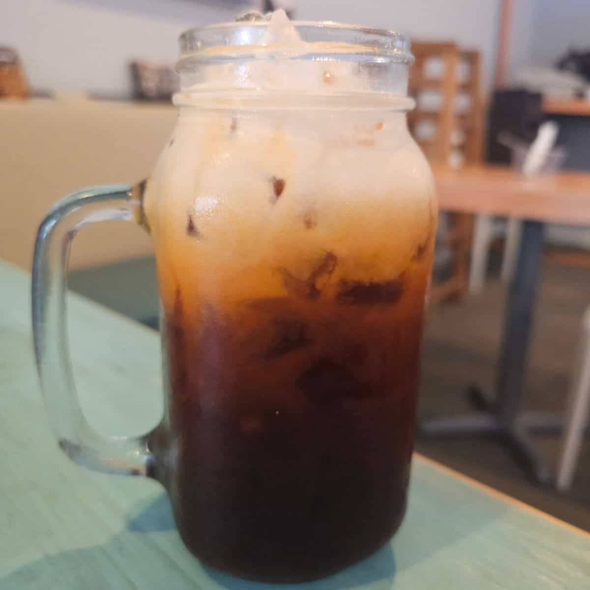thai tea in a mason jar glass on a table