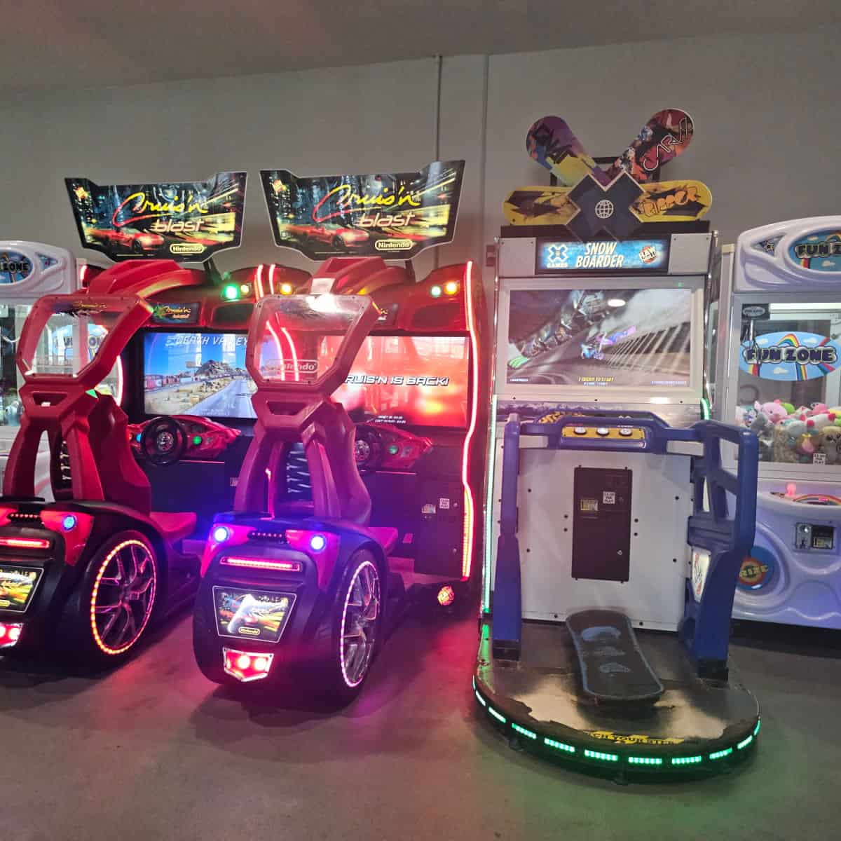 arcade area at Oasis with two car games, snowboarder, and fun zone