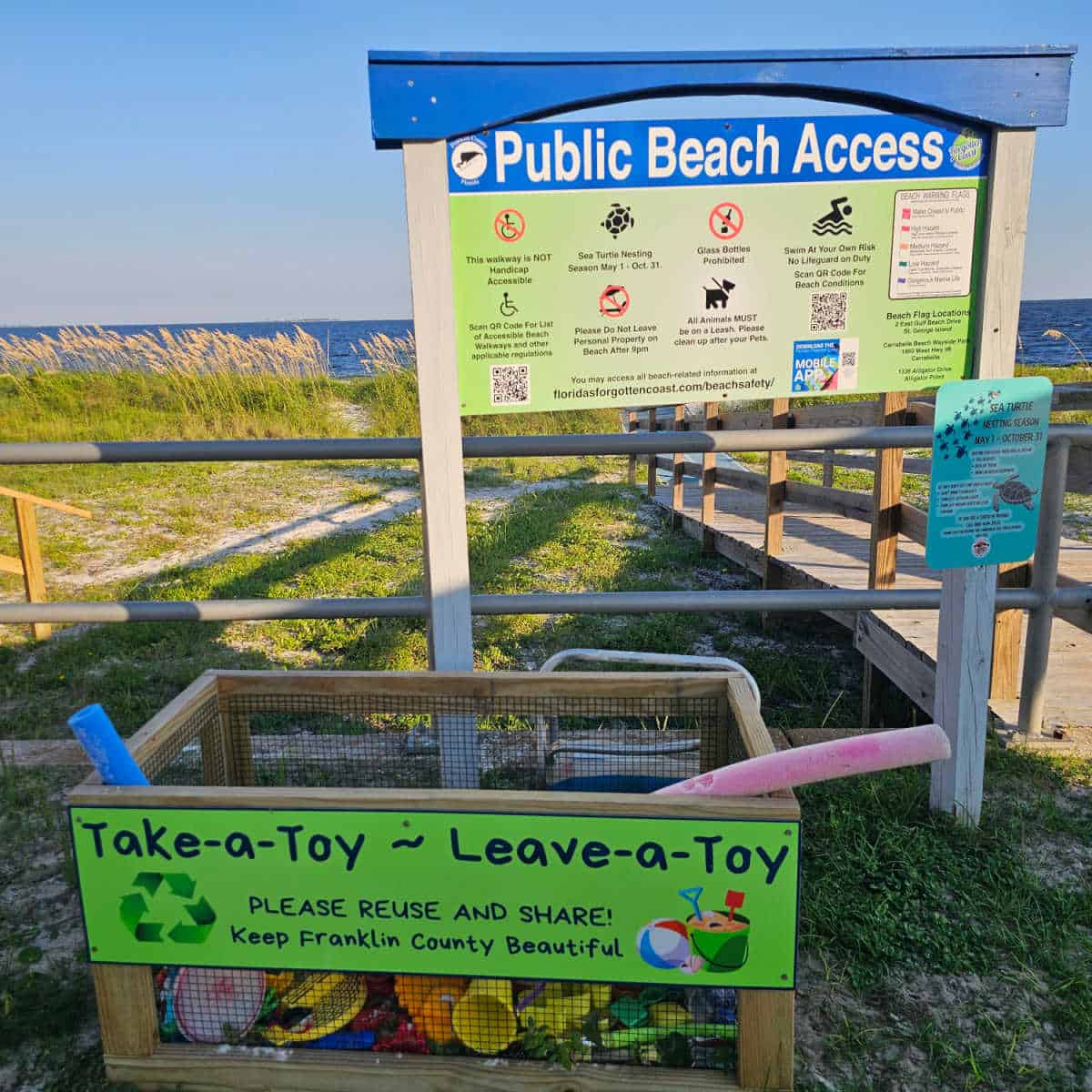 public beach access sign with take a toy and leave a toy box