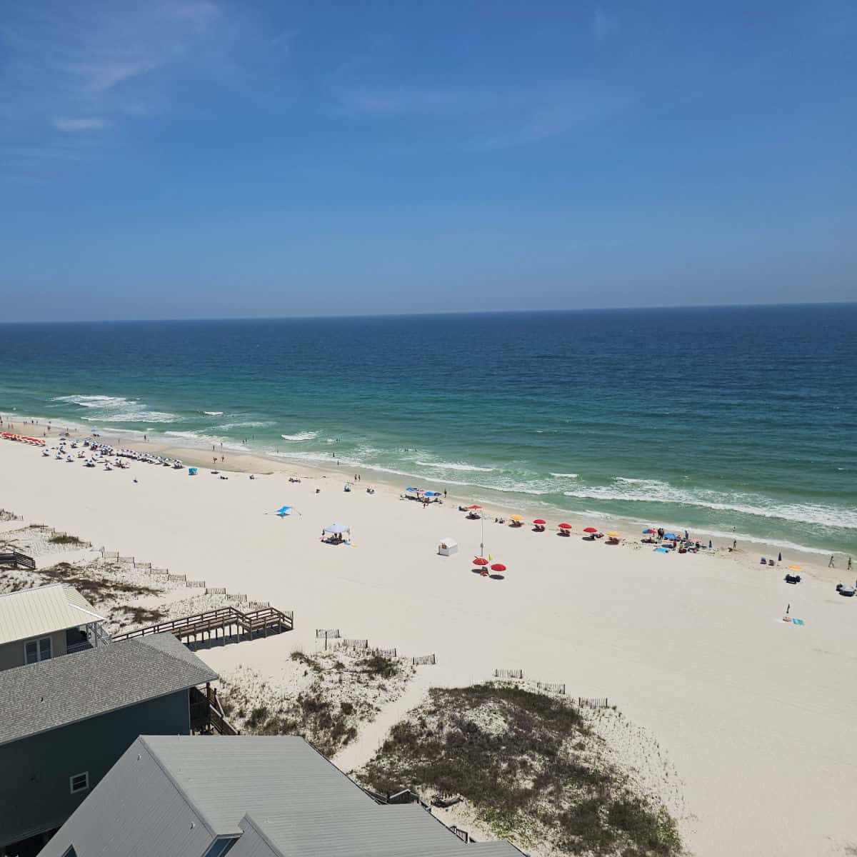 looking over the beach with colorful umbrellas to the Gulf