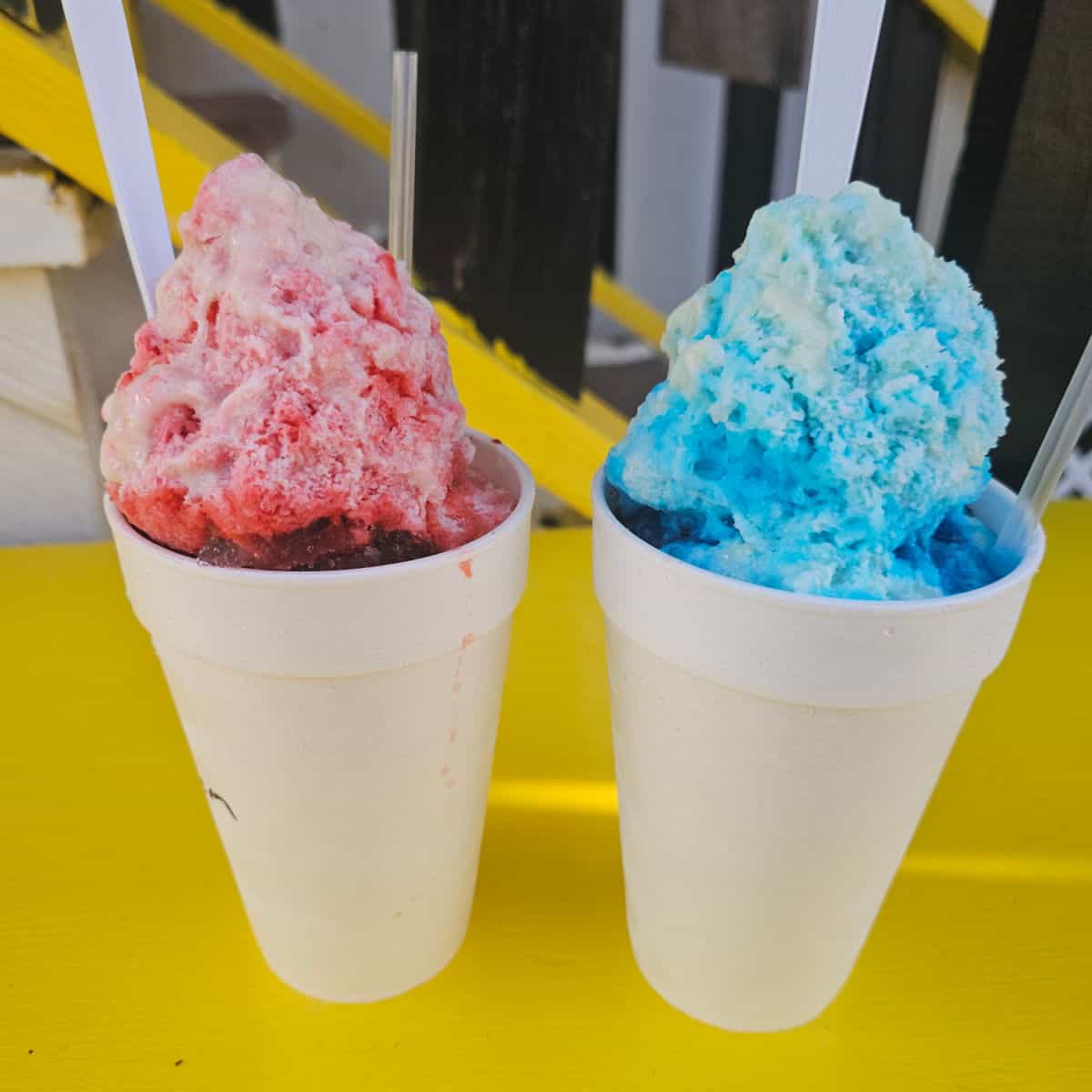 Red and blue snoballs in white styrofoam cups