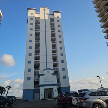 Perdido Dunes Tower on the front of a white tall building with blue accents