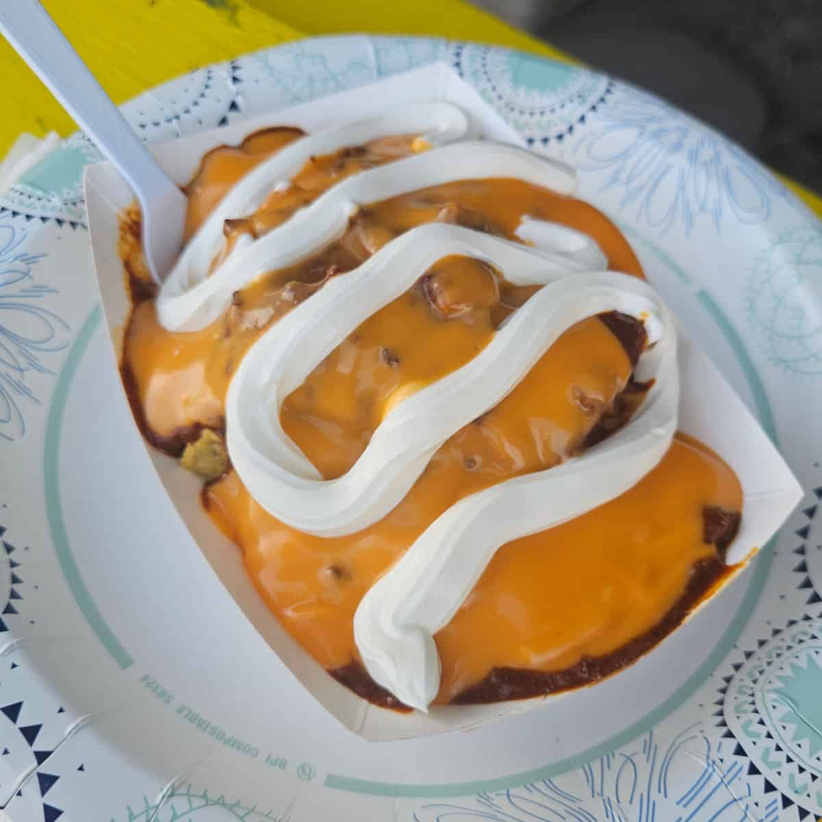 Frito Pie on a white plate with a plastic fork