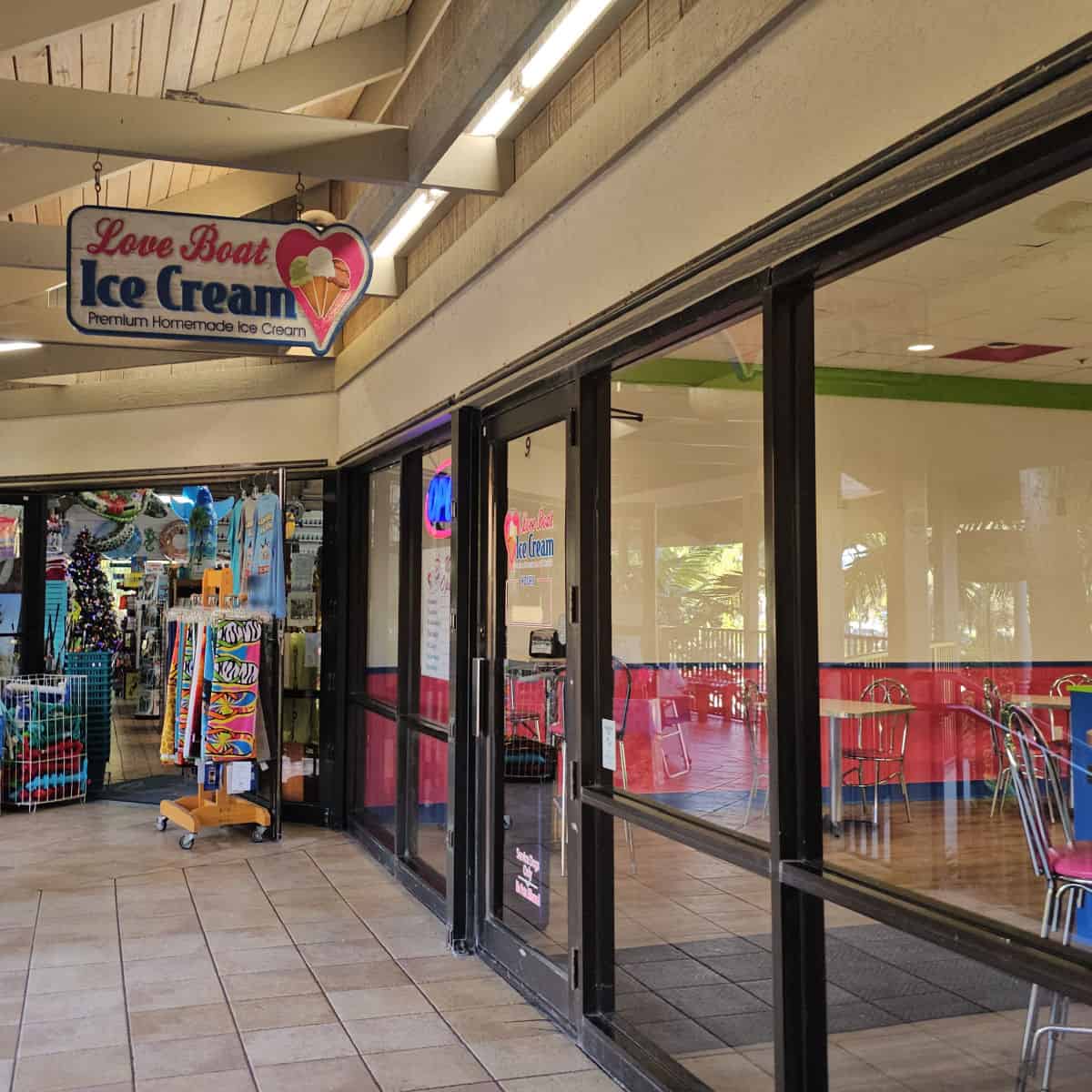 Love Boat Ice Cream sign over the entrance to the restaurant with large glass windows, souvenir shop in the background