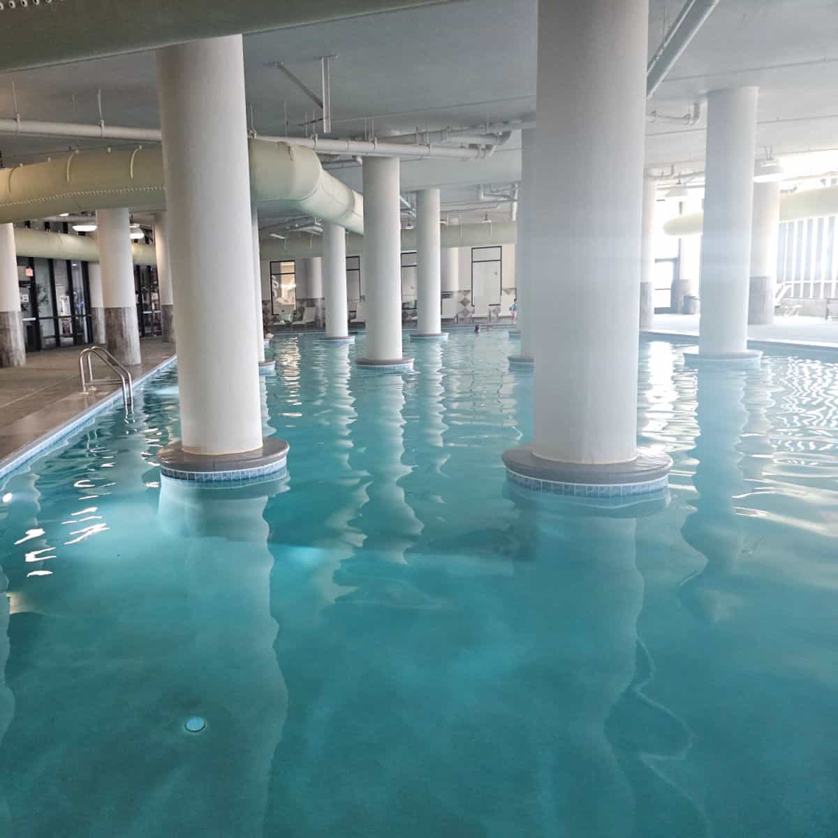indoor pool with large white columns in the pool.