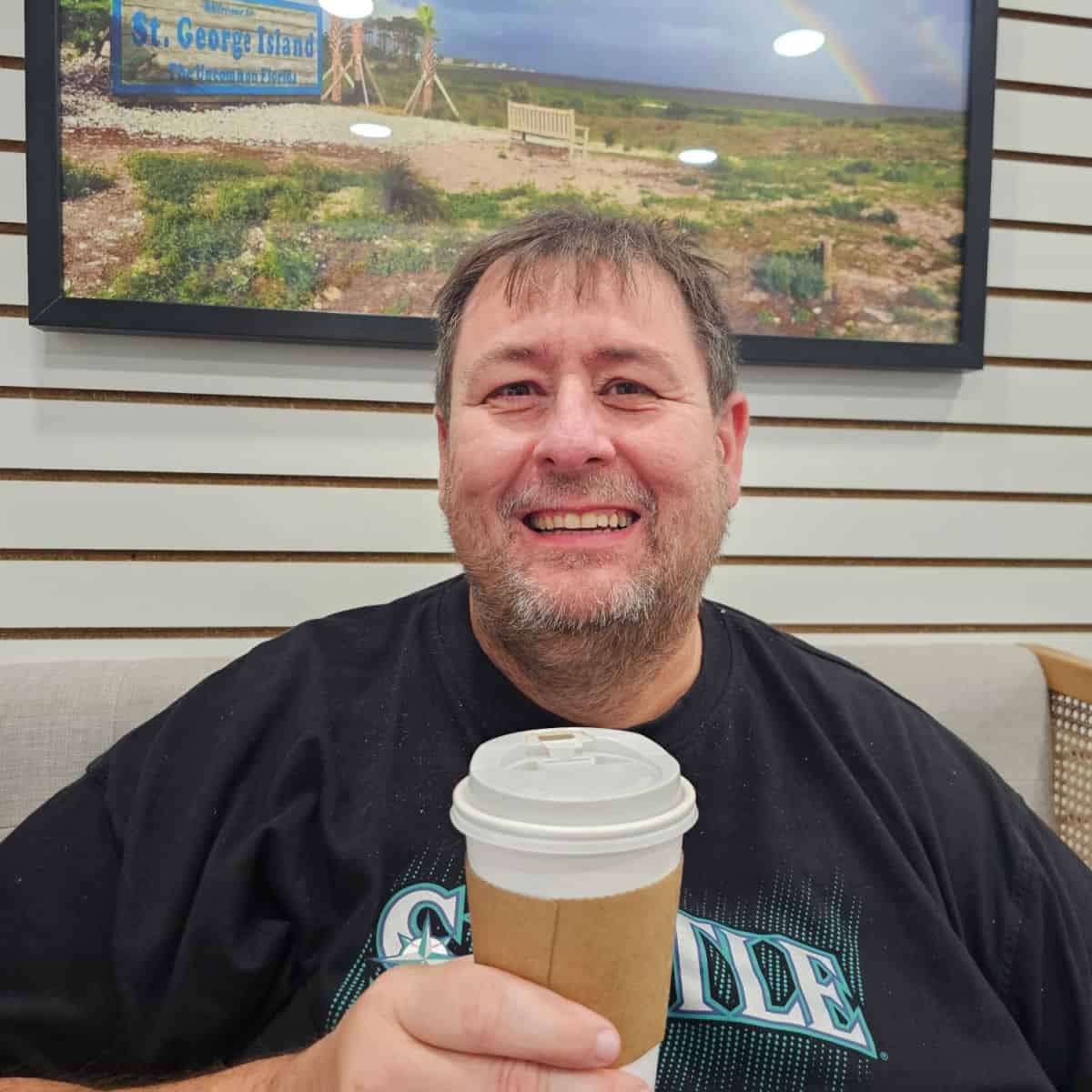 John holding an espresso with st george island art behind him