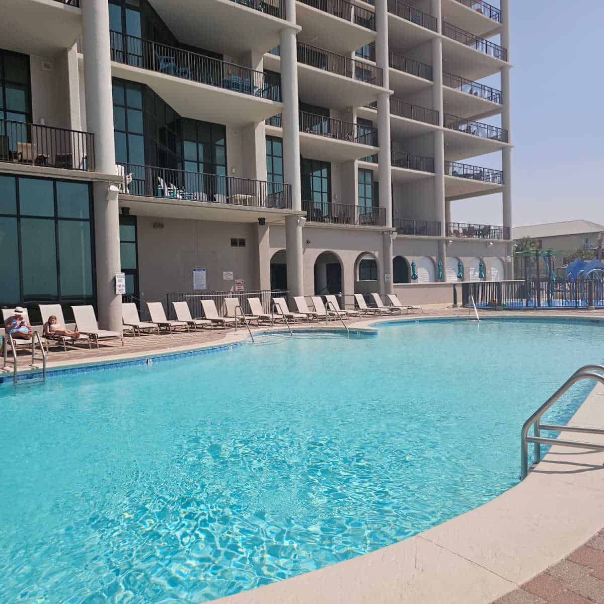 pool with lounge chairs along the side, Oasis building behind the pool