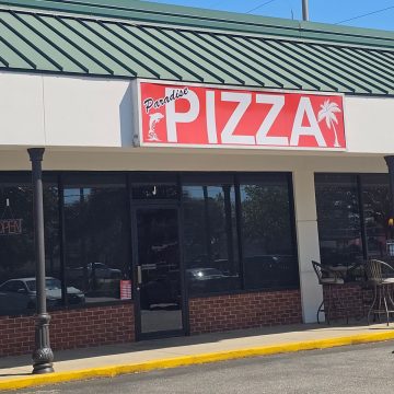 Paradise Pizza sign over the dark windows of a restaurant