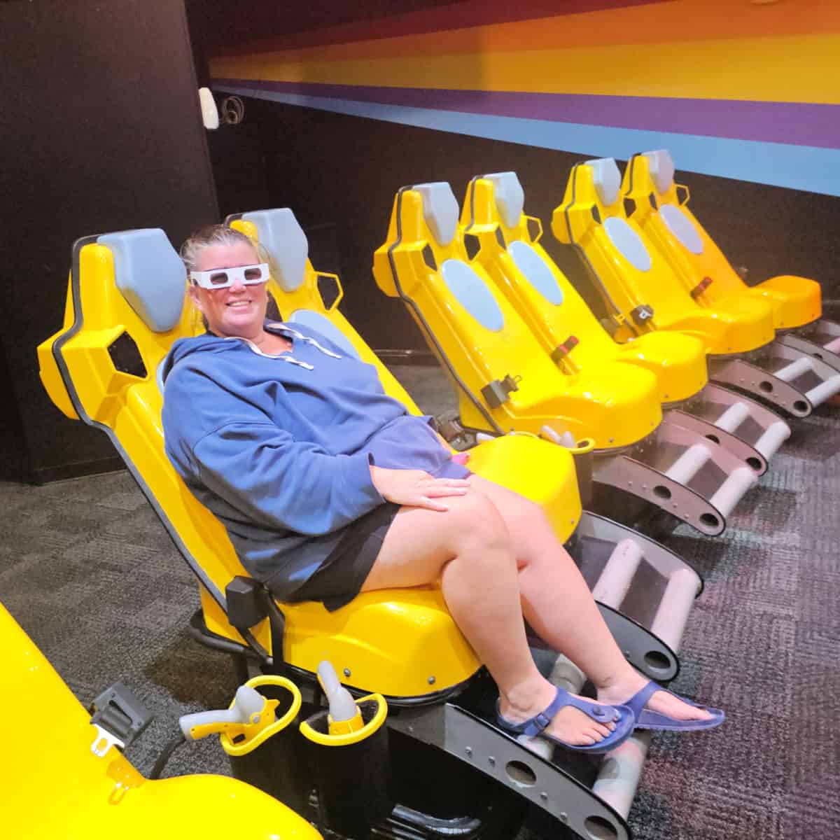 Tammilee in a yellow chair wearing 3-d glasses, yellow chairs in a row
