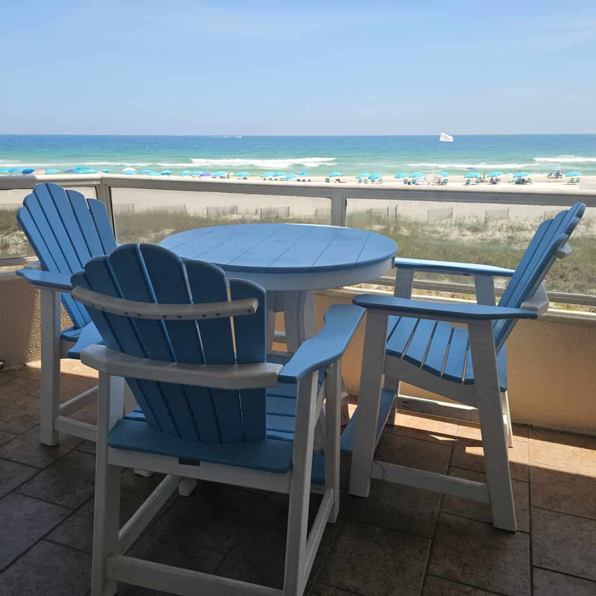 balcony with blue and white table and chairs looking out to the beach and Gulf