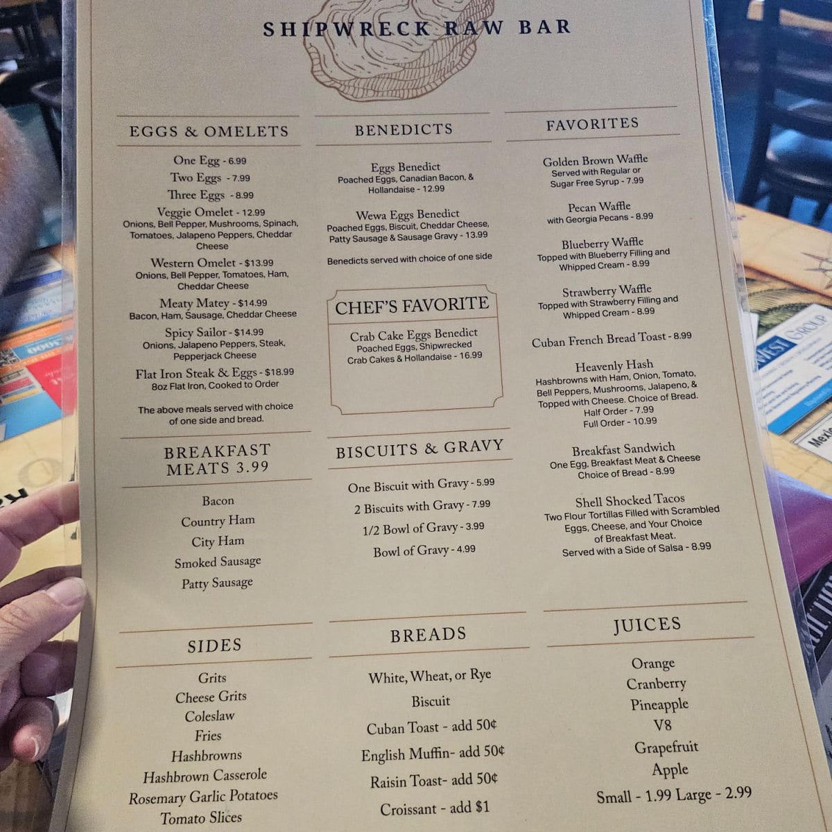 Shipwreck Raw Bar menu with eggs & omelets, benedicts, favorites, biscuits and gravy, sides, breads, and juices