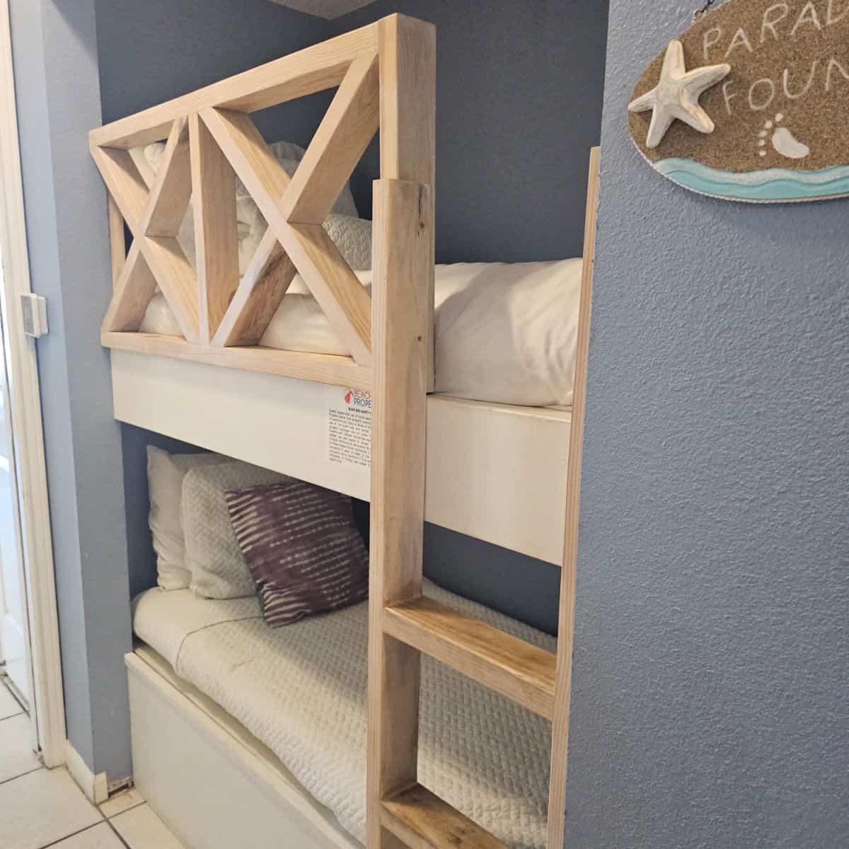 bunk bed built into the wall with white linens