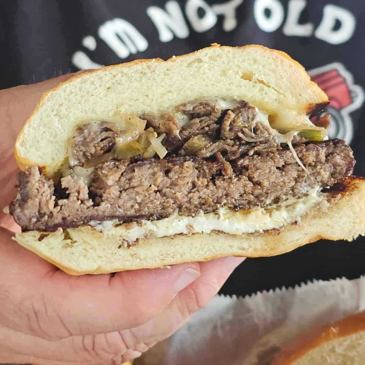 hand holding a cheeseburger