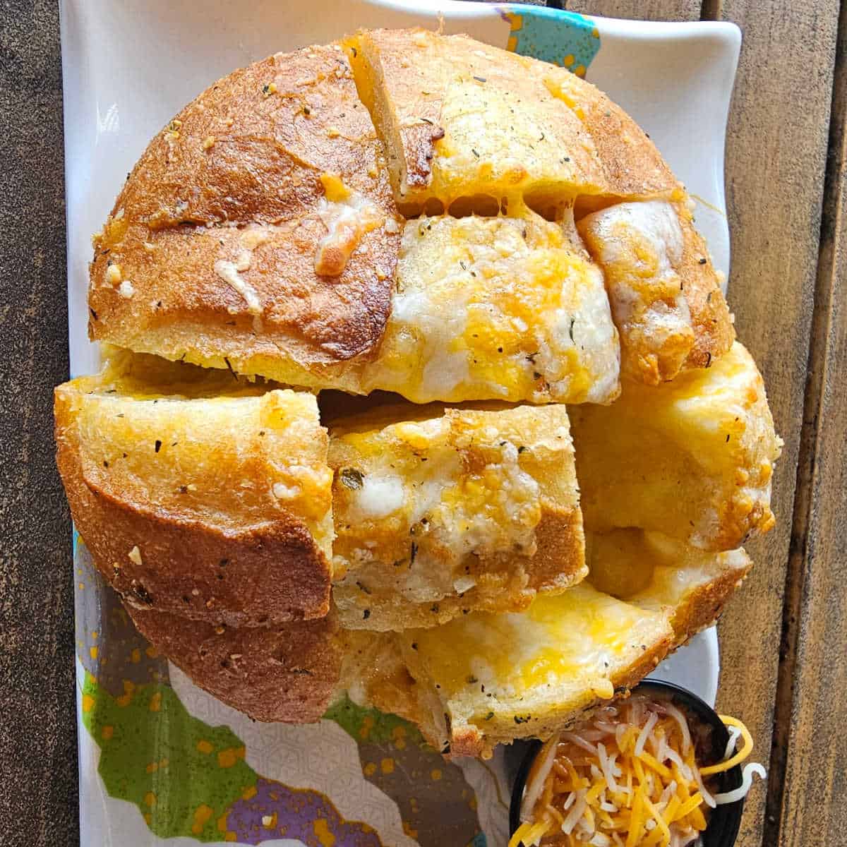 looking down on cheesy bread on a white platter