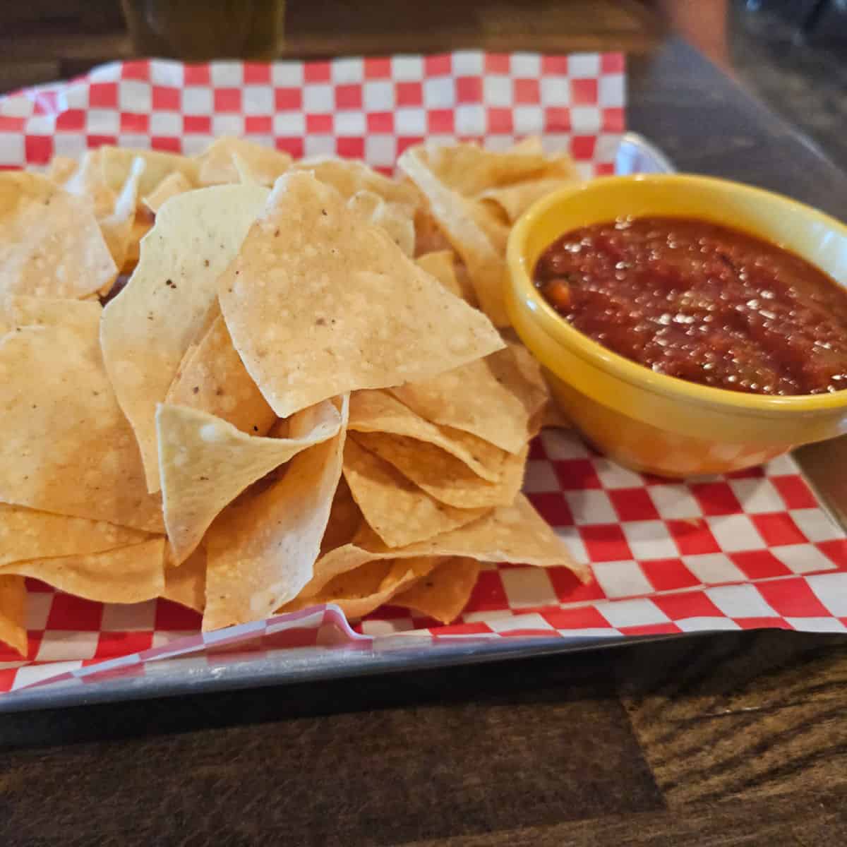 chips and salsa on a red and white checkered platter