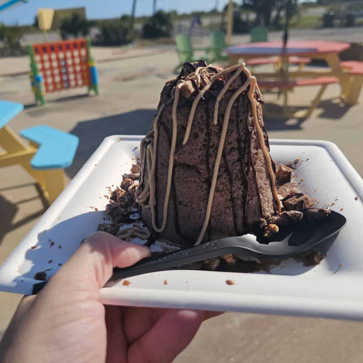 chocolate snow on a white plate with a plastic spoon