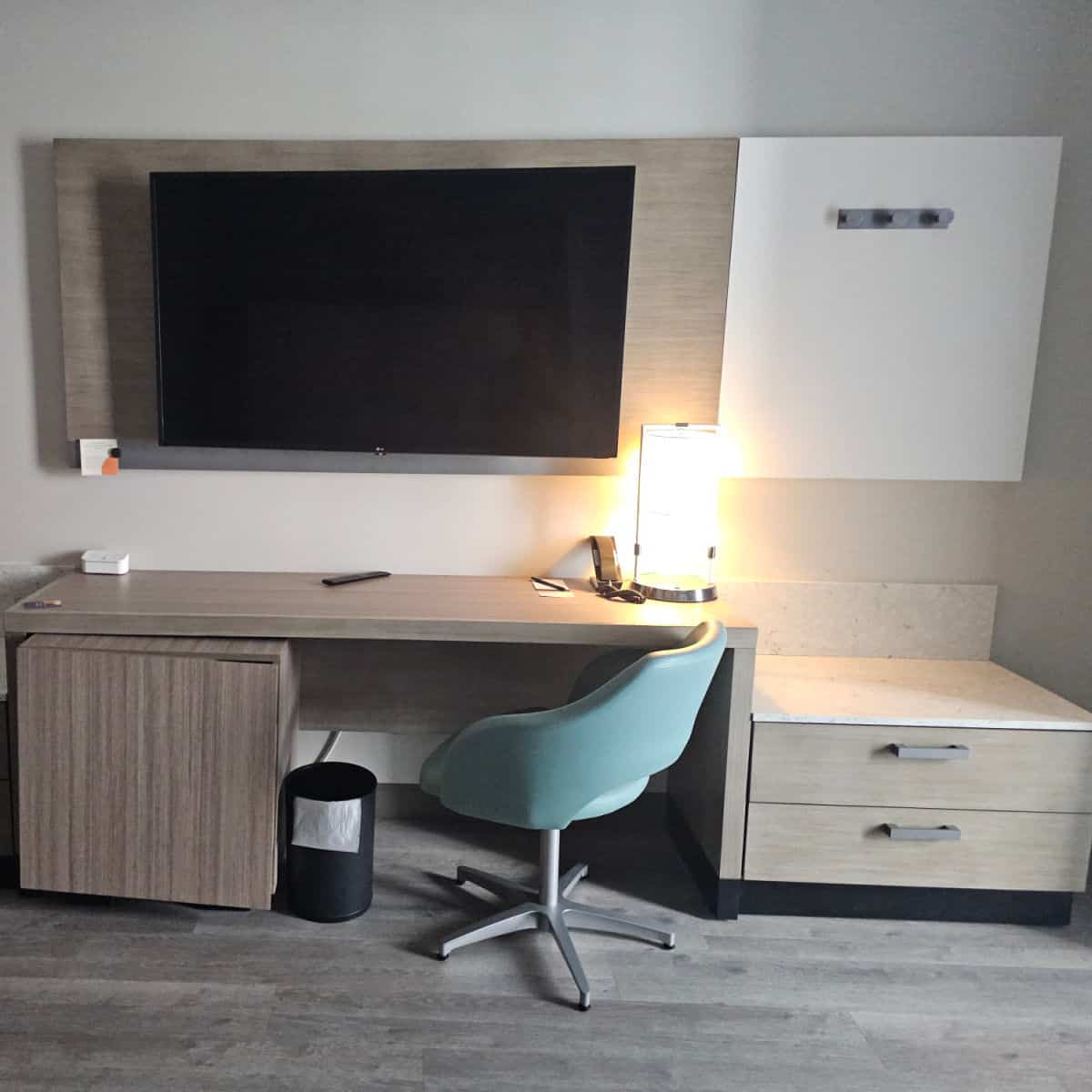 work area in a hotel room with flatscreen tv on the wall