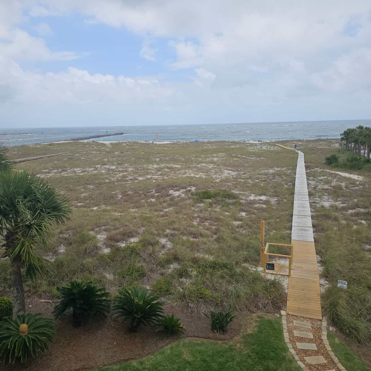 boardwalk leading over the sand dunes to the beach and Gulf waters in the distance