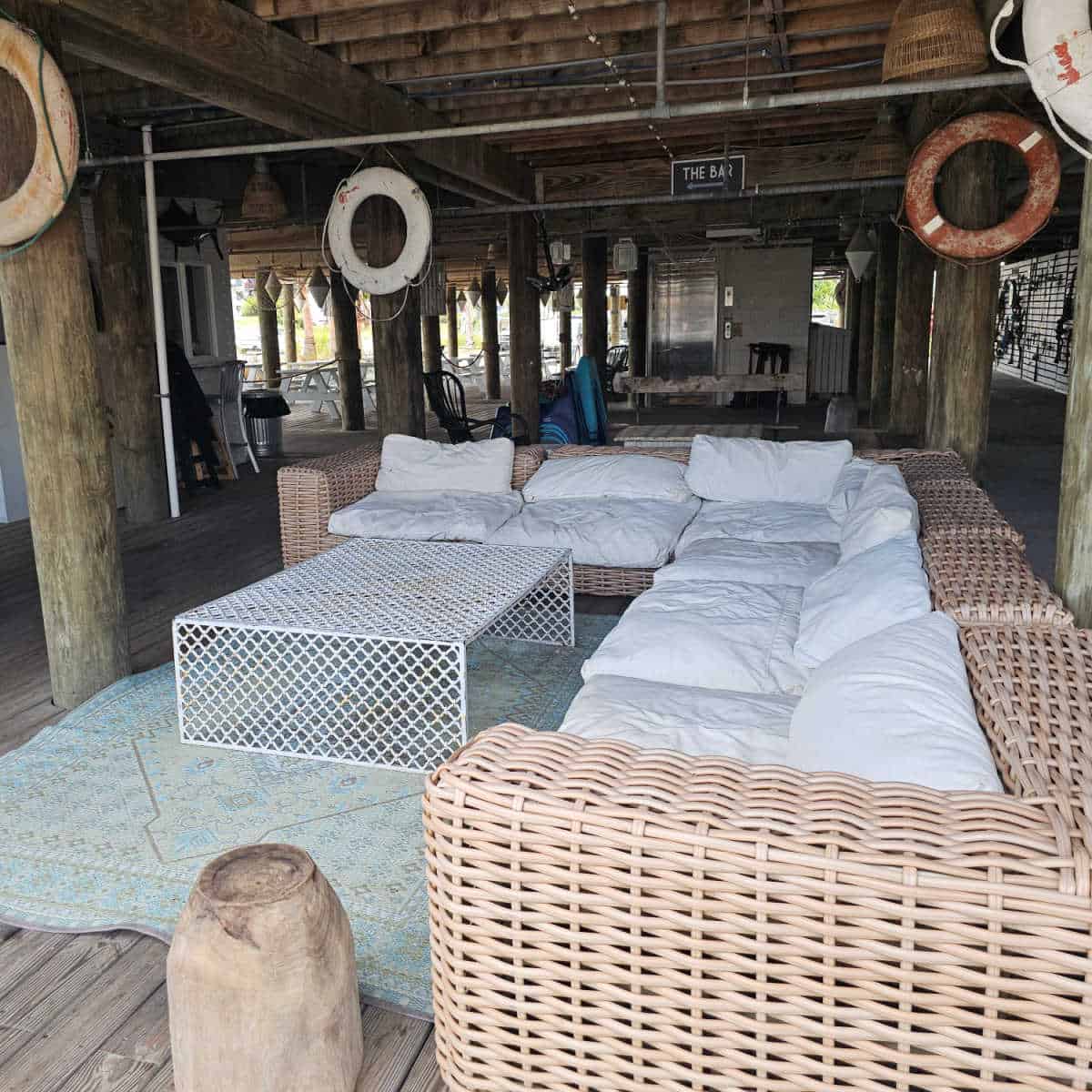 seating under the restaurant with a large couch with white cushions and a white table