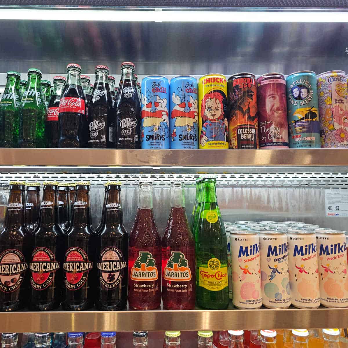 different types of sodas and drinks in a refrigerator case