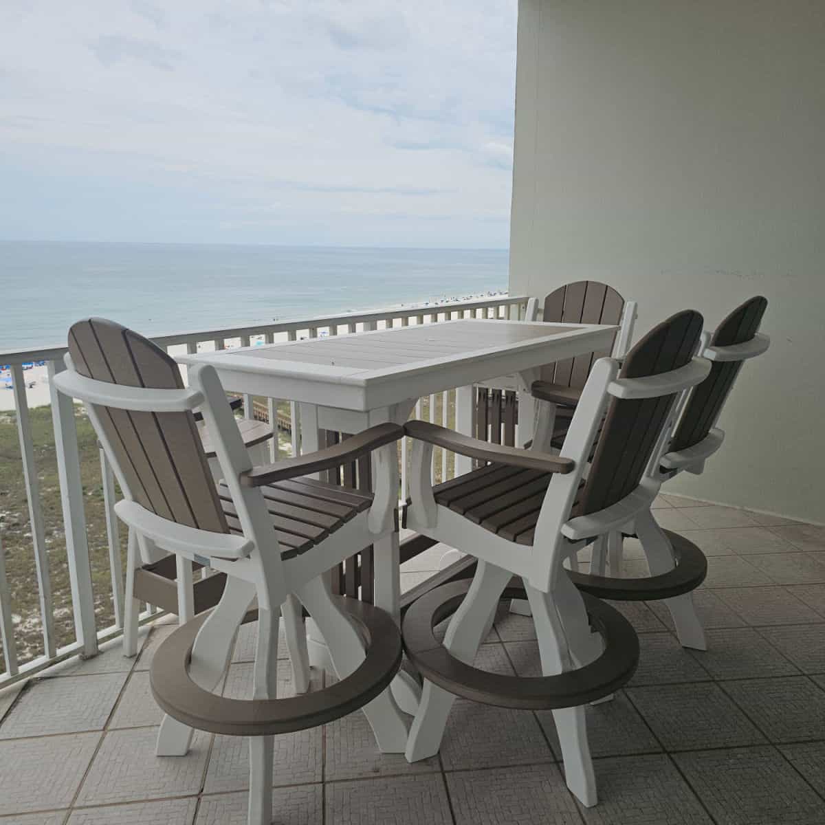 balcony with table and chairs looking out to the beach and Gulf waters