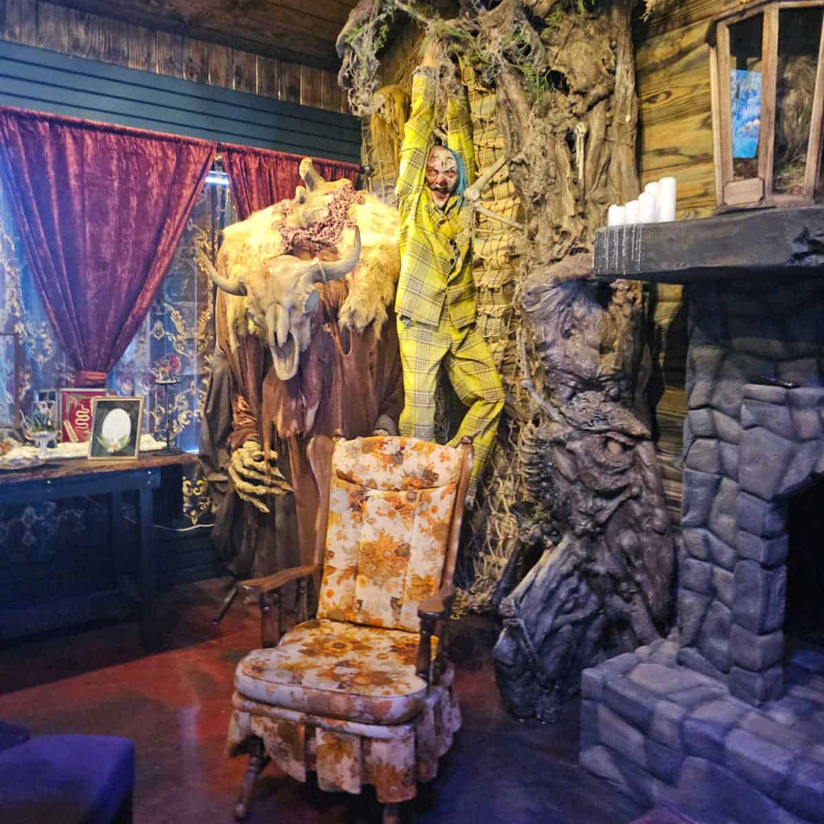 Styx & Bones Oddities Cafe interior with a skull creature, creepy clown, tree and fireplace along wiht an old rocking chair