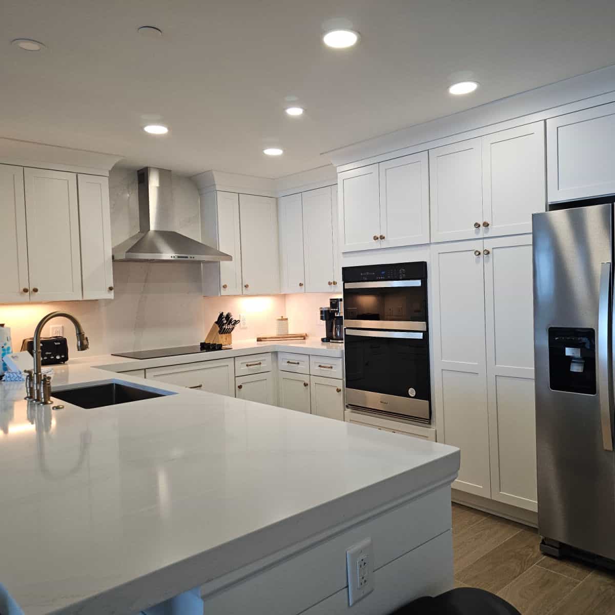 Kitchen with white cabinets, stainless steel appliances, and white countertop