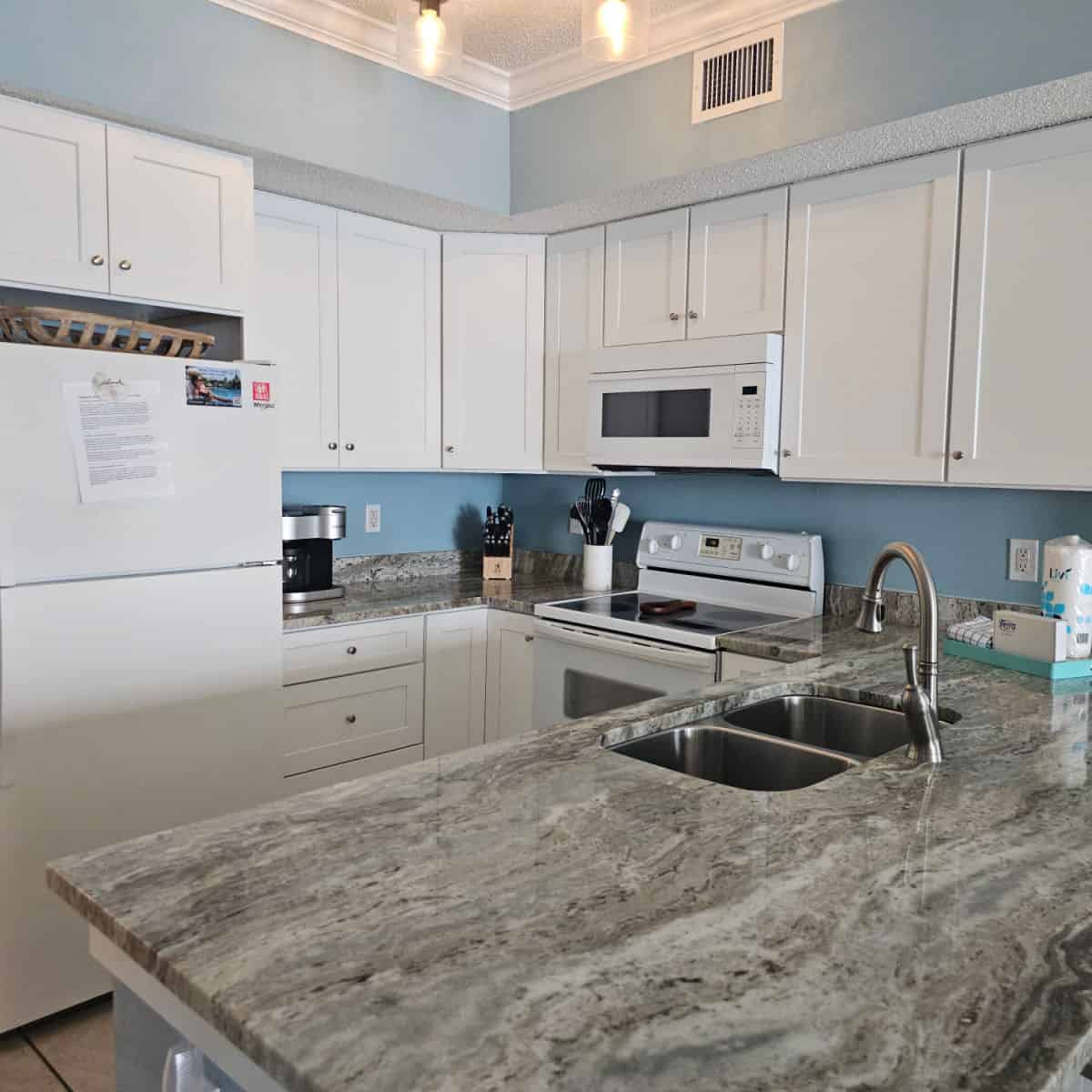 kitchen with white cabinets, white appliances and grey stone counters