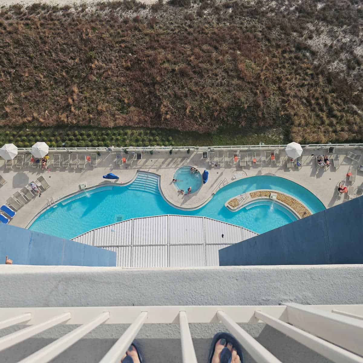 looking down from the balcony to the curved pool and hot tub