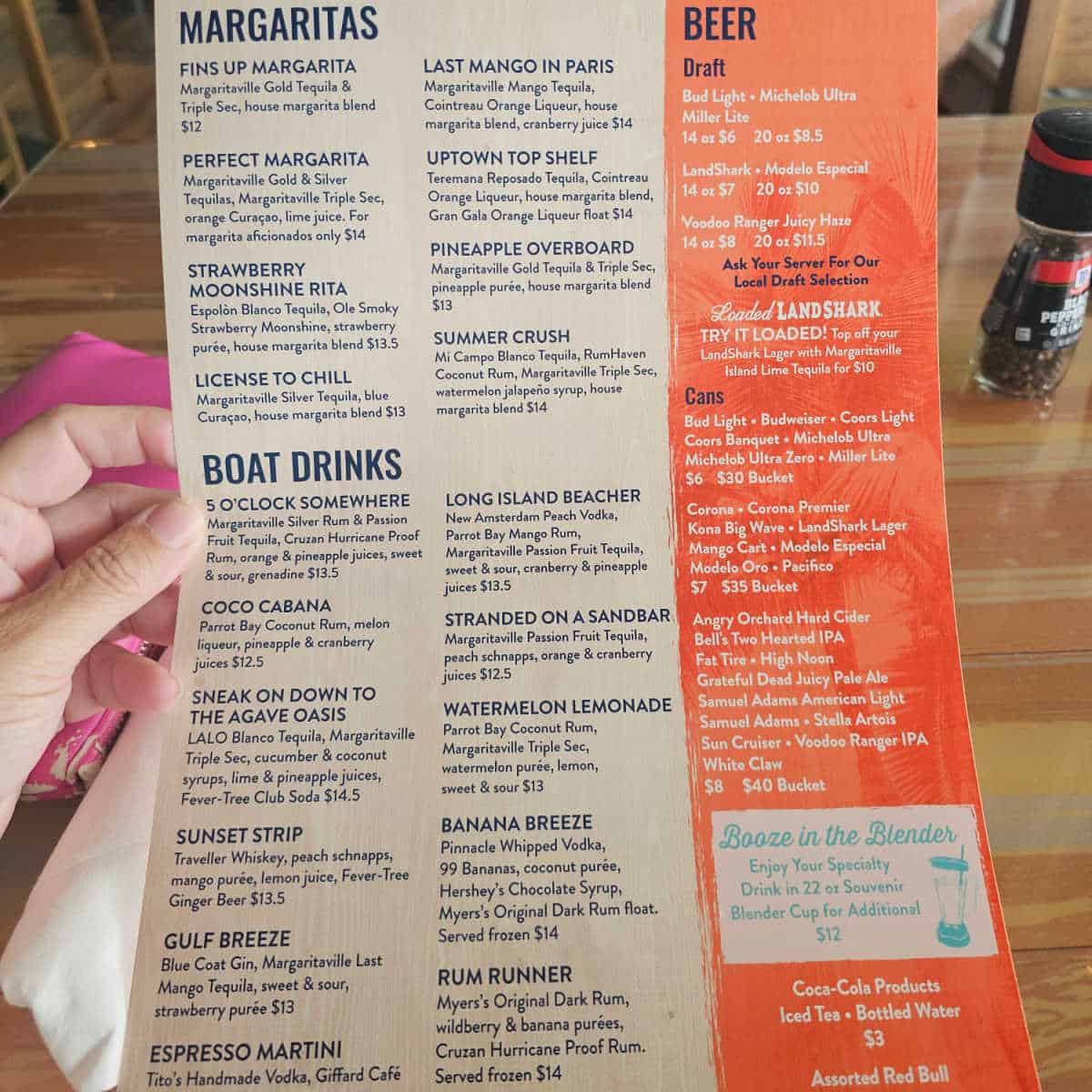 hand holding the Last Mango menu with margaritas boat drinks beer and booze in the blender menu