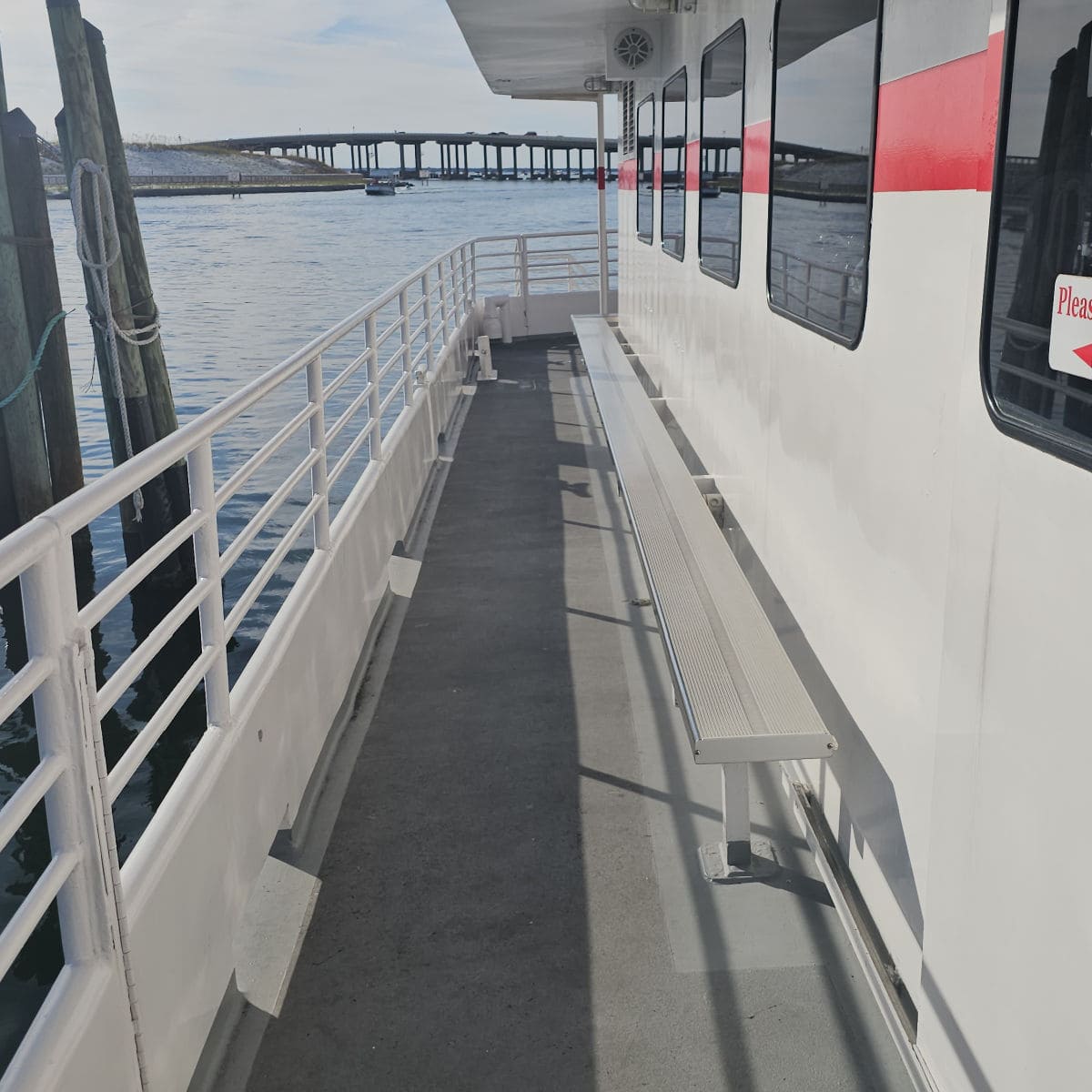 bench seating along the side of the Southern Star dolphin cruise with the Destin bridge in the background