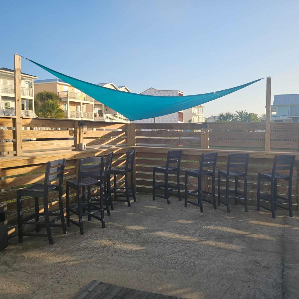 outdoor seating with a floating cover, tall chairs around a wooden ledge